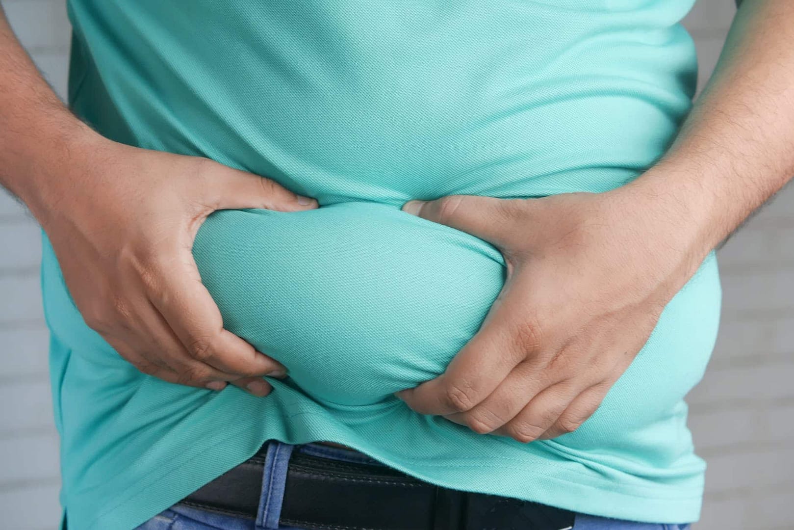 a person holding his belly fat