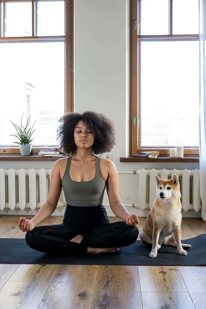 woman meditating beside her dog