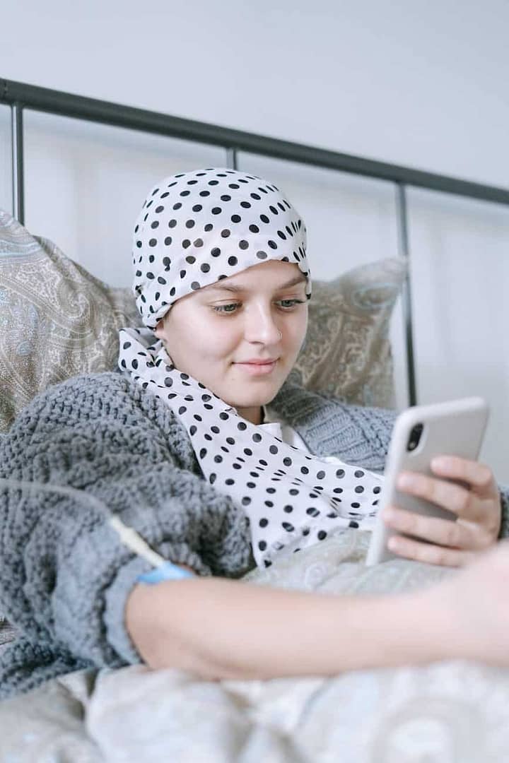 woman in bed using her smartphone